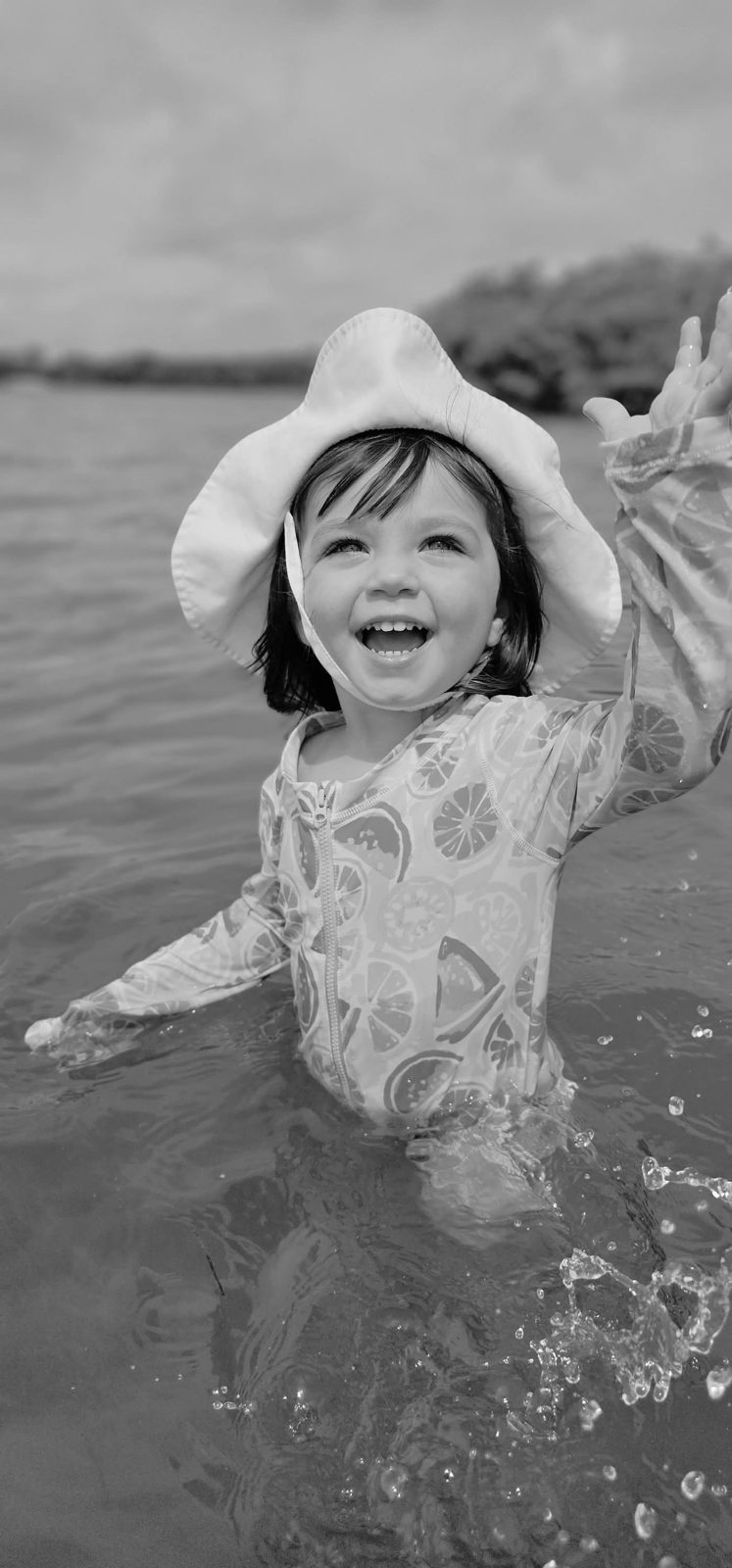 Toddler laughing and splashing in the water