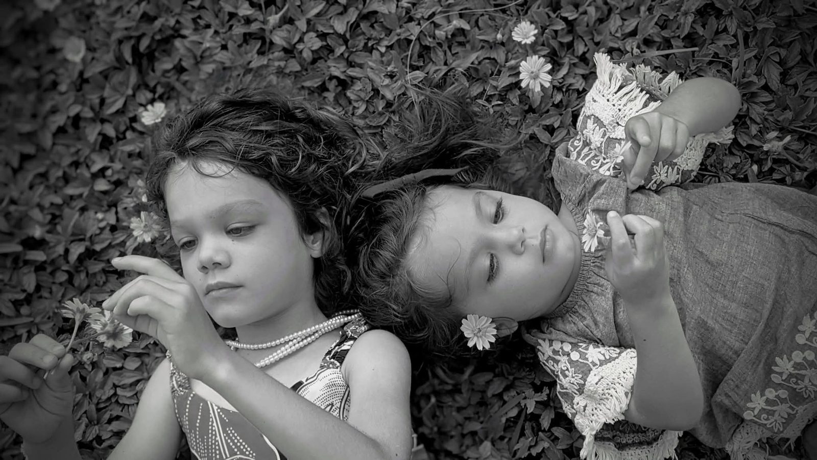 Sisters lying in flowers, black and white