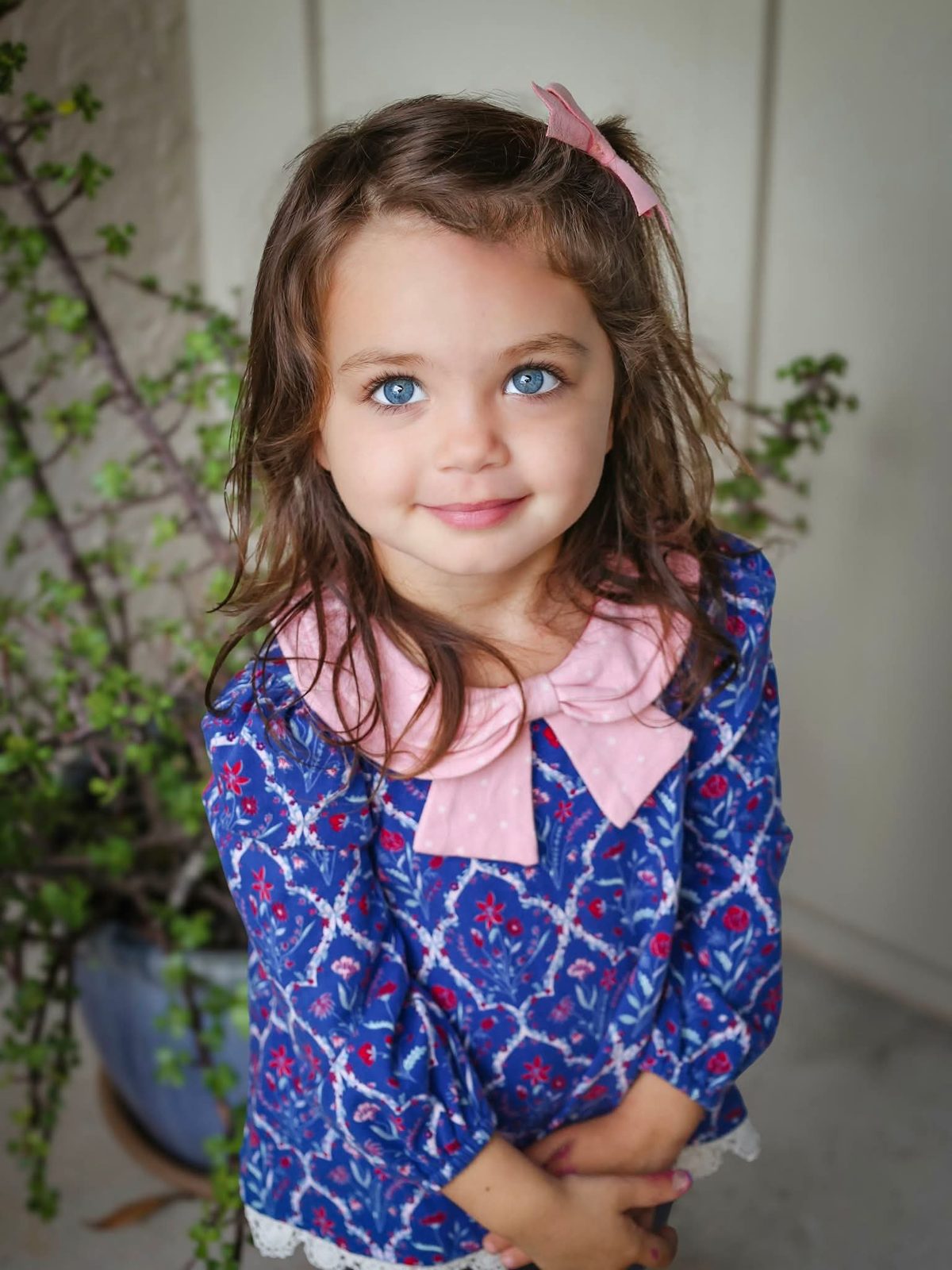 Girl in a floral top with a pink bow collar